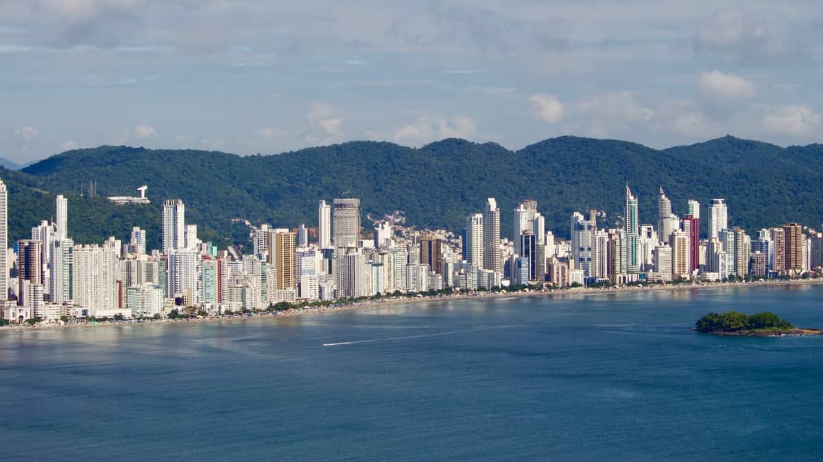 Edifícios de Balneário Camboriú vistos do mar, com morros ao fundo