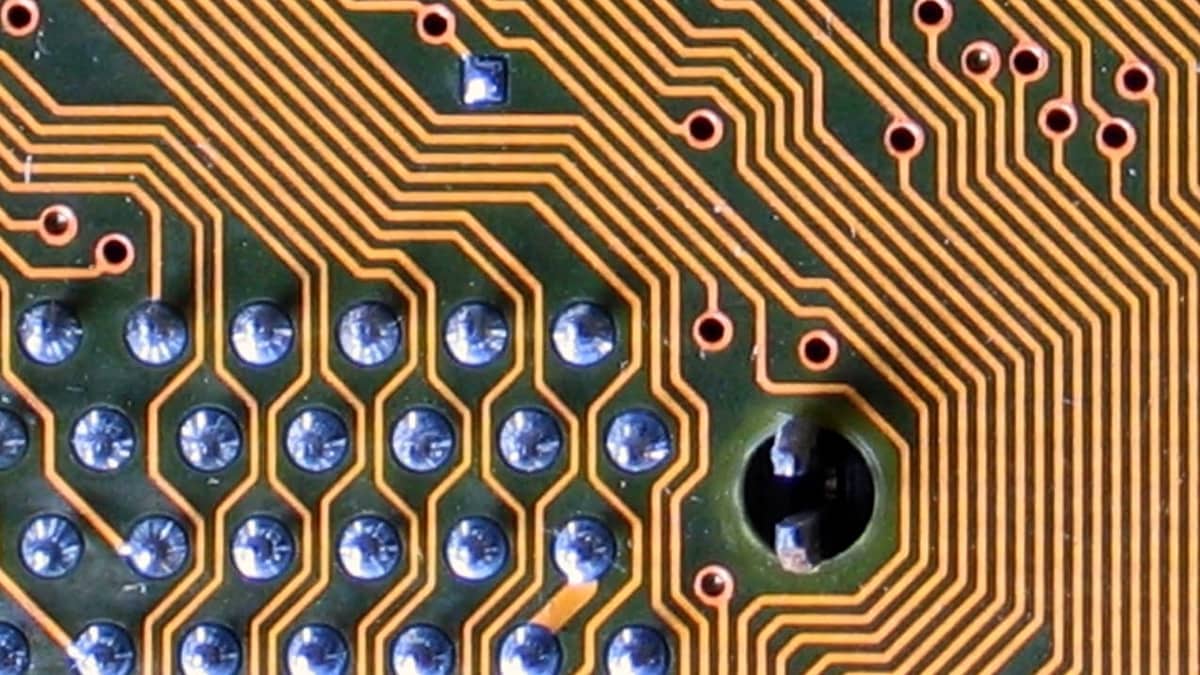 Detalhe de placa de circuito eletrônico com trilhas douradas. Imagem ilustrativa