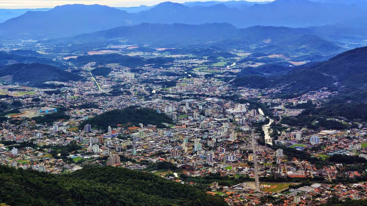 Vista panorâmica de Jaraguá do Sul, com a cidade em vale cercado por morros