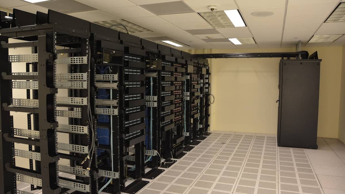 Fileiras de racks de servidores em sala de equipamentos. Imagem ilustrativa