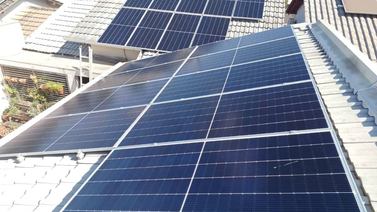 Painéis solares fotovoltaicos instalados sobre um telhado. Imagem ilustrativa